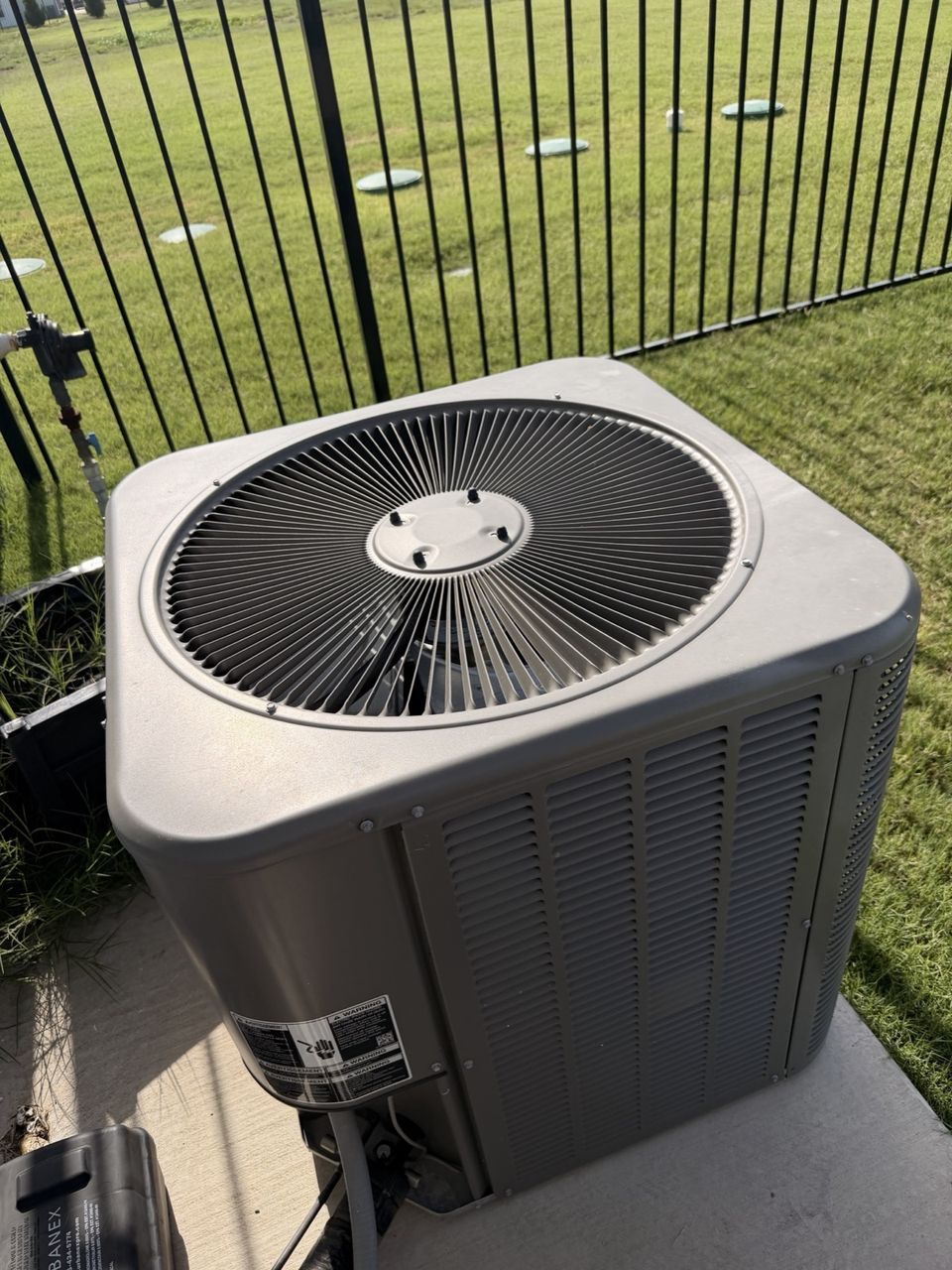 Newly installed air conditioning condenser sitting on its pad outside a home in Allen, Texas