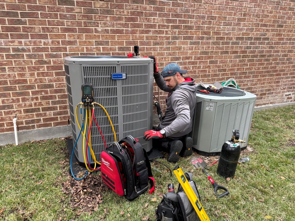 Refrigerant gauges connected to an outdoor air conditioner during a repair call in McKinney