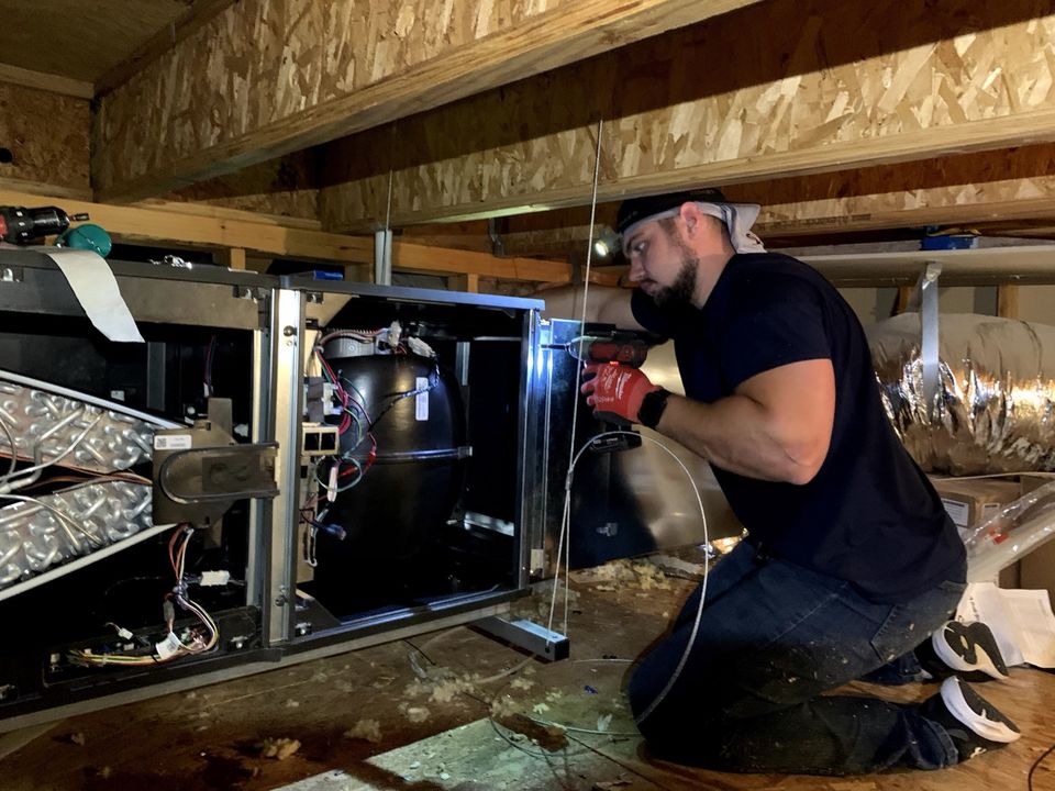 SmartWay technician working on a furnace installed in a home attic