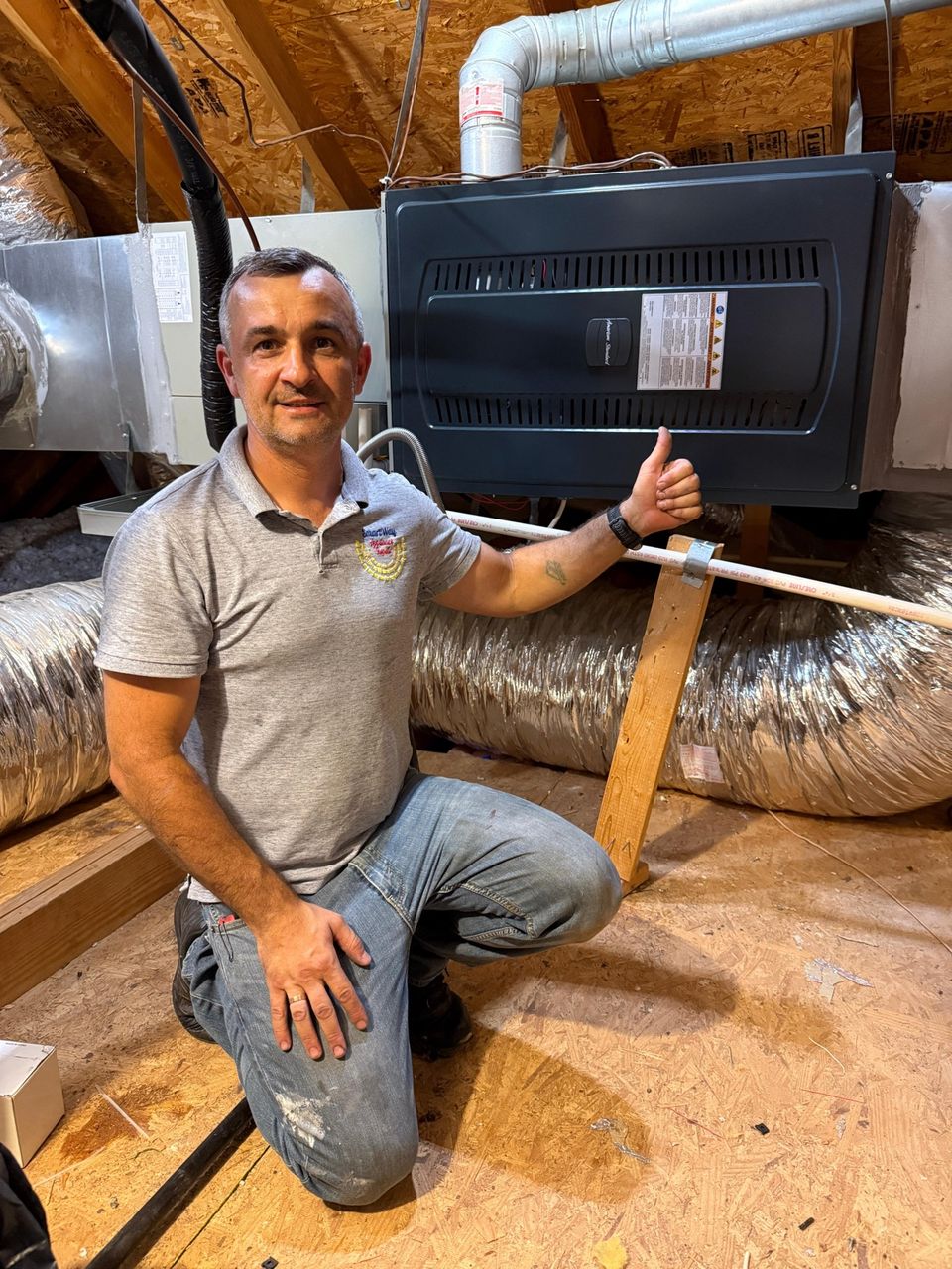 SmartWay owner Eugene next to a newly installed furnace in a home attic
