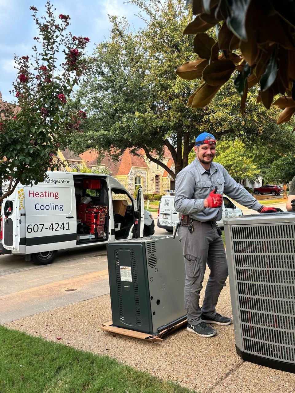 SmartWay technicians carrying a new air conditioning condenser unit by hand to the install location