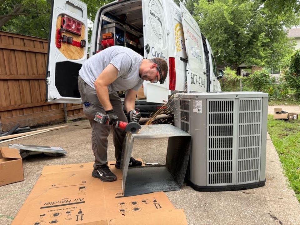 SmartWay technician unloading a new condenser from a SmartWay van in a backyard