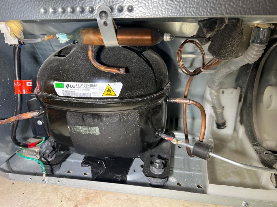 LG inverter compressor, copper filter drier and refrigerant lines in the back compartment of a refrigerator