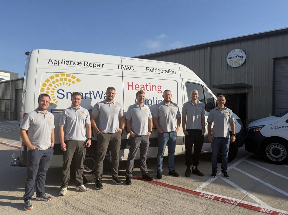 Seven SmartWay technicians in gray polos standing in front of a lettered SmartWay van at the McKinney shop